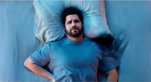 Person lying on a mattress with their head resting on a pillow for comfortable sleep support.