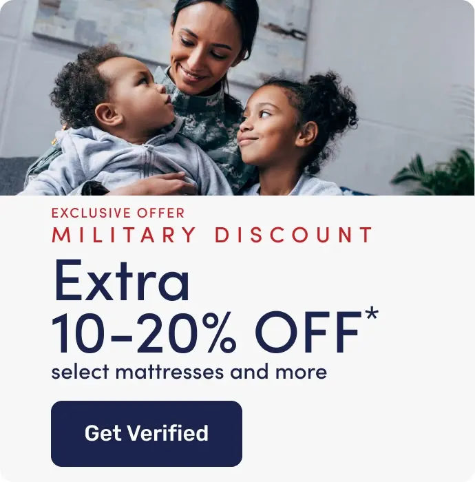 Military family sitting together on a couch with an American flag blanket, next to a banner promoting a military discount of an extra 10–20% off select mattresses and more, with a button to get verified.